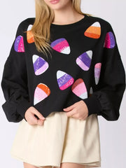 Halloween Candy Sequin Long-Sleeve Sweatshirt featuring colorful candy corn sequins on a black background.