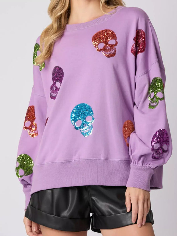 Halloween Colorful Skull Sequin Oversized Sweatshirt featuring vibrant sequin skulls on a lavender background.
