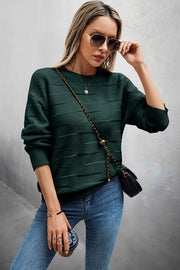 Model wearing a Classic Round Neck Loose Knit Sweater in green, styled with jeans and sunglasses.