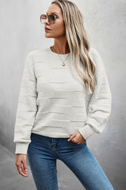 Woman wearing a Classic Round Neck Loose Knit Sweater styled with sunglasses and jeans.