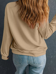 Woman wearing a relaxed drop-shoulder sweatshirt, showcasing the back view, styled with light denim jeans.