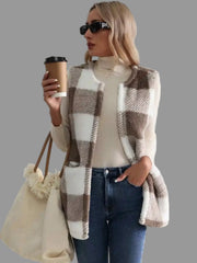 Woman in plaid sherpa vest coat holding a coffee cup, styled for effortless everyday fashion.