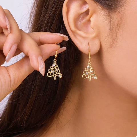 18K Gold Christmas Tree Earrings displayed on a model's ear, showcasing festive holiday sparkle and style.