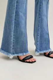 Close-up of Judy Blue High Waist Flare Fray Hem Jeans with Pintuck Detail showcasing the frayed hem and fashionable fit.