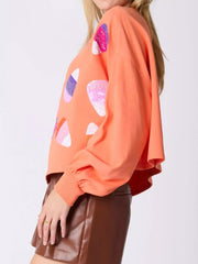 Model showcasing Halloween Candy Sequin Long-Sleeve Sweatshirt with colorful sequin candy designs.