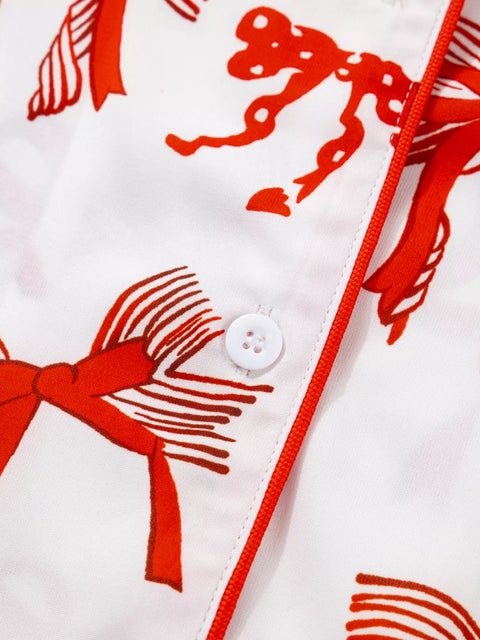 Close-up of the Buttoned Two-Piece Set featuring a white fabric with red bow prints and a button detail.