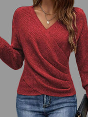 Stylish model wearing a Surplice Long Sleeve Knit Top with ribbed detailing and V-neckline, paired with jeans.