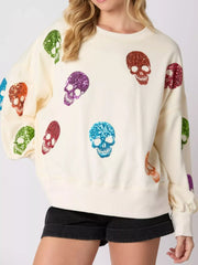 Halloween Colorful Skull Sequin Oversized Sweatshirt with colorful sequin skulls on a cozy cream background.