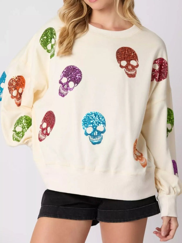 Halloween Colorful Skull Sequin Oversized Sweatshirt with colorful sequin skulls on a cozy cream background.