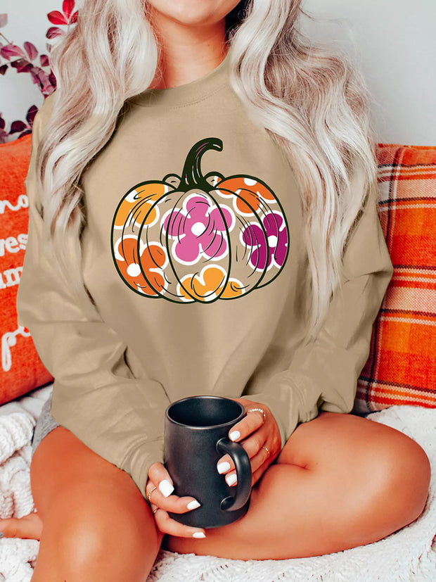 Halloween Floral Pumpkin Graphic Drop-Shoulder Sweatshirt worn by a woman sitting with a cup, featuring a floral pumpkin design.